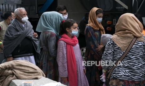 Keluarga yang dievakuasi dari Kabul, Afghanistan, menunggu untuk naik bus setelah mereka tiba di Bandara Internasional Washington Dulles, di Chantilly, Va, pada Minggu, 29 Agustus 2021.