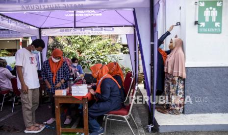 Sejumlah warga menjalani pemeriksaan kesehatan sebelum disuntik vaksin Covid-19 saat pelaksanaan vaksinasi Covid-19 massal. 