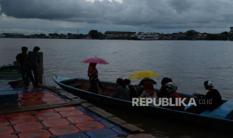 Sejumlah warga menaiki perahu motor di tengah hujan (ilustrasi). Hujan lebat disertai petir diprediksi terjadi di Kalimantan Tengah selama 3 hari ke depan.