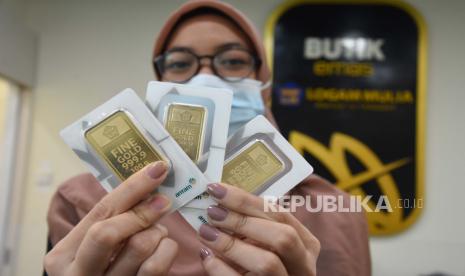 Petugas menunjukkan emas batangan yang dijual di Butik Emas Antam, Jakarta, Selasa (28/7). Harga emas Antam dirilis Rp 1.013.000 per gram pada perdagangan Rabu (29/7) ini.