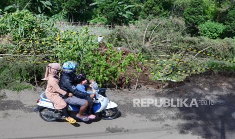 Warga melewati pohon tumbang akibat angin kencang, di Jalan Bukit Maribaya, Kecamatan Lembang, Kabupaten Bandung Barat, beberapa waktu lalu.