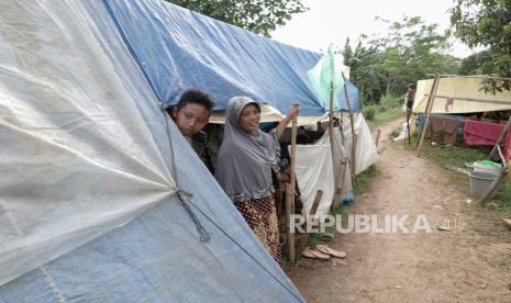 Sejumlah warga korban banjir membangun tenda darurat di atas tanggul sungai di Desa Gentasari, Kroya, Cilacap, Jateng, Kamis (19/11/2020). Sejumlah 305 warga Grumbul Karag, Desa Gentasari, Kroya, Cilacap, memilih membuat tenda darurat untuk mengungsi di atas tanggul sungai, yang bersebelahan dengan rumah mereka yang terendam banjir, karena khawatir dengan keselamatan harta benda mereka.  