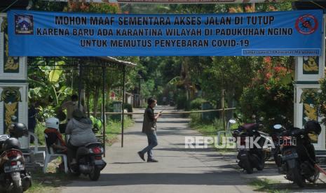 Petugas berjaga di pintu masuk kampung saat karantina wilayah di Padukuhan Ngino XII, Margoagung Sleman, D.I Yogyakarta, Jumat (18/6/2021). Sejak 16 Juni 2021, Padukuhan Ngino XII dan Ngino XI melakukan karantina wilayah guna memutus penyebaran Covid-19 menyusul sejumlah warga di kampung itu terpapar Covid-19 seusai melakukan ziarah. 