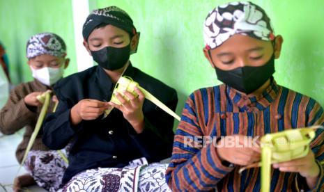 Siswa menggunakan pakaian adat Jawa membuat ketupat di SD Winongo, Bantul, Yogyakarta, Rabu (21/4/2022). Siswa SD menggunakan pakaian adat Jawa dalam rangka memperingati Hari Kartini. Kebetulan Hari Kartini tahun ini bertepatan dengan Ramdhan, sehingga siswa diberikan latihan membuat ketupat.