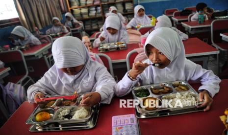 Para siswa menyantap hidangan Makan Bergizi Gratis (MBG) di SDN 05 Sukatani, Depok, Jawa Barat, Senin (6/1/2025). 