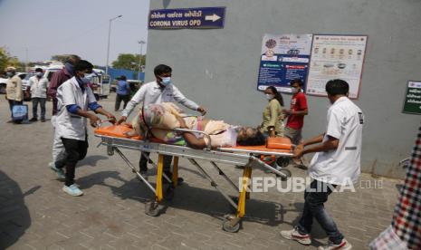 Tenaga kesehatan membawa pasien Covid-19 di rumah sakit pemerintah Covid-19, Ahmedabad, India, Selasa (27/4). Kasus Covid-19 di India melonjak lebih cepat daripada di tempat lain di dunia. Tercatat angka kematian di India akibat virus Covid-19 telah mencapai 200.000 jiwa. (AP Photo/Ajit Solanki)