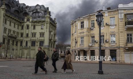 Orang-orang berjalan di jalan saat asap mengepul di udara setelah penembakan di Odesa, Ukraina, Ahad, 3 April 2022. Perdana Menteri Kanada Justin Trudeau mengutuk pembunuhan warga sipil di kota Bucha, Ukraina.