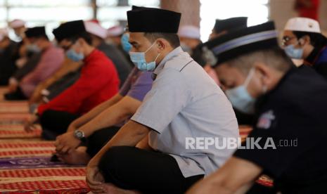 Umat Muslim mengenakan masker dan menerapkan jarak sosial berdoa di dalam Masjid 