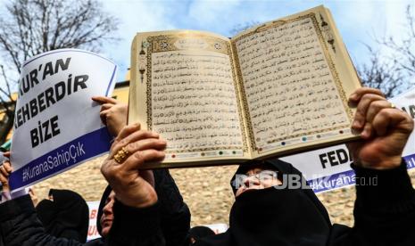 Seorang demonstran wanita memegang Alquran saat melakukan protes di depan Konsulat Jenderal Swedia, di Istanbul, Turki, 22 Januari 2023. Demonstran berkumpul setelah politikus sayap kanan Swedia-Denmark Rasmus Paludan diizinkan menggelar demonstrasi dan membakar salinan Alquran di depan kedutaan Turki di Stockholm pada 21 Januari 2023.