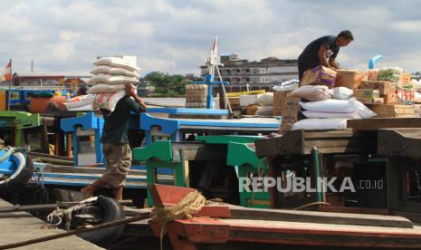 Seorang buruh angkut memanggul karung beras ke atas kapal kayu di Pelabuhan Kapuas Besar, Pontianak, Kalimantan Barat, Senin (1/6/2020). Kapal motor dari kayu yang menjadi salah satu alat transportasi air di Sungai Kapuas tersebut mengangkut penumpang dan barang kebutuhan rumah tangga dan lainnya untuk dijual kembali di daerah Kabupaten Kubu Raya dan hulu Sungai Kapuas