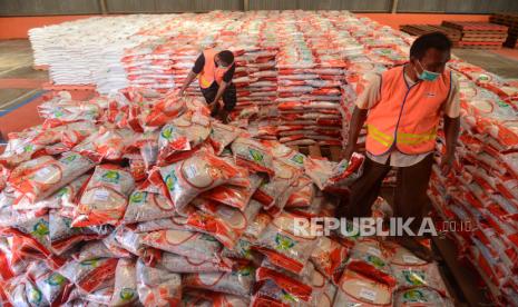 Petugas mempersiapkan beras bantuan PPKM  hasil panen petani tahun 2021 saat proses penyaluran di Gudang Perum Bulog.  ilustrasi