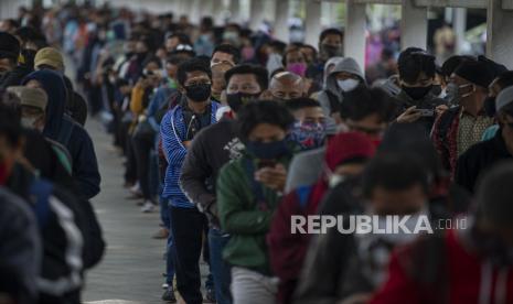 Sejumlah calon penumpang Kereta Rel Listrik (KRL) Commuterline mengantre memasuki Stasiun KA Bogor di Kota Bogor, Jawa Barat, Senin (29/6/2020). Pembatasan penumpang di dalam KRL maupun di area peron menyebabkan antrean panjang penumpang di stasiun tersebut. Untuk mengurainya, pemerintah menyediakan bus gratis dan PT Kereta Commuter Indonesia mengujicobakan sistem informasi mengenai antrean melalui laman utama di aplikasi KRL Acccess dan media sosialnya. ANTARA FOTO/Aditya Pradana Putra/wsj.  *** Local Caption *** 