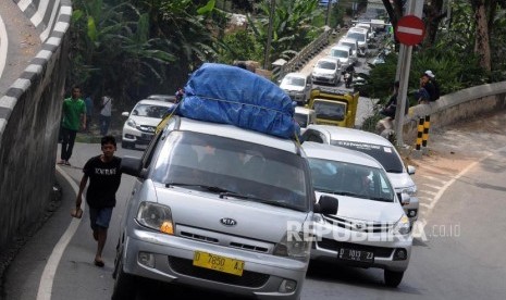 Warga usai mengganjal ban mobil pemudik di kawasan Nagreg, Kabupaten Bandung, Jawa Barat, Rabu (13/6).