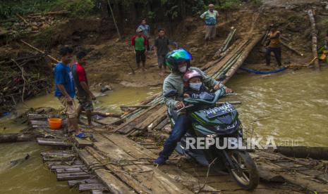 Pengendara motor melintasi jembatan darurat di Desa Murung B, Kecamatan Hantakan, Kalimantan Selatan, Senin (8/11/2021). Jembatan darurat berbahan kayu dan bambu tersebut menjadi jembatan sementara untuk aktivitas warga Desa Murung B dan Desa Patikalain karena jembatan utama ambruk terbawa arus luapan sungai yang tinggi akibat hujan deras beberapa hari. 