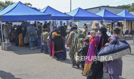  Dalam gambar yang disediakan oleh Angkatan Udara AS ini, para pengungsi Afghanistan berbaris untuk diproses di Pangkalan Udara Ramstein, Jerman, Sabtu, 21 Agustus 2021. 