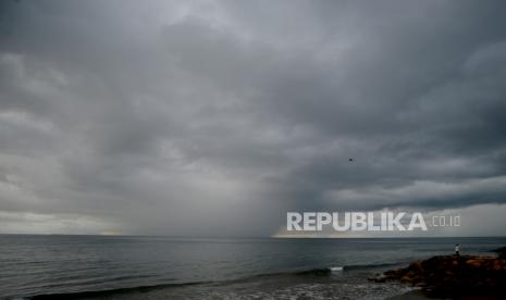 Warga melihat awan hujan di Pantai Padang, Sumatera Barat, Kamis (9/12/2021). Badan Meteorologi Klimatologi dan Geofisika (BMKG) menjelaskan siklon tropis Nalgae yang terpantau di Laut Filipina atau di sebelah utara-timur laut Tahuna, Kepulauan Sangihe, bergerak menjauhi wilayah Indonesia.