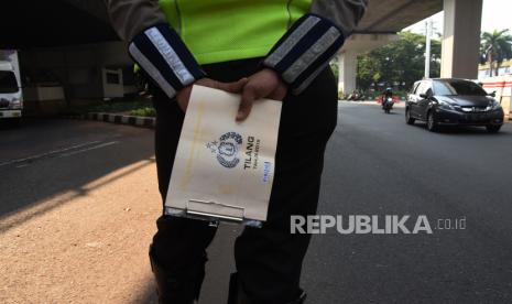 Pelanggar Ganjil-Genap Makin Berkurang di Jam Sibuk. Polantas memantau kendaraan saat hari pertama pemberlakuan kembali kebijakan ganjil-genap kendaraan.