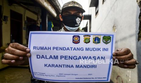 Lurah Lenteng Agung Bayu Pasca memperlihatkan stiker tanda sedang menjalani isolasi mandiri untuk pemudik di kawasan Lenteng Agung, Jakarta, Senin (17/5). Pemerintah Kota Jakarta Selatan menginstruksikan setiap kelurahan untuk menempelkan stiker tanda isolasi mandiri di rumah pemudik yang baru datang dari kampung halaman untuk mencegah penyebaran Covid-19.  Republika/Putra M. Akbar