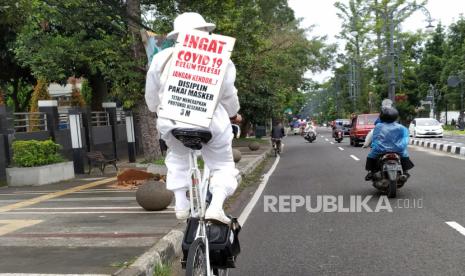 Seorang pesepeda membawa tulisan mengingatkan warga agar tetap menerapkan protokol kesehatan pencegahan Covid-19 yaitu 3M (memakai masker, menjaga jarak dan mencuci tangan), di Jalan Ir H Djuanda, Kota Bandung, Ahad (6/12). Tidak hanya petugas penanganan Covid-19, warga dan sejumlah komunitas pun turut andil mengingatkan penerapan protokol kesehatan menyusul kembalinya Kota Bandung bersetatus zona merah.