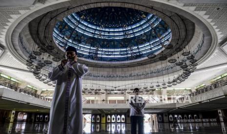 Muadzin mengumandangkan Adzan sebelum melaksanakan Shalat Dzuhur berjamaah di Masjid At-Tin, Jakarta.