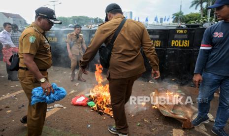 Massa Gabungan dari Asosiasi Kepala Desa se-Indonesia (Apdesi) berusaha memadamkan api saat menggelar aksi di depan Gedung DPR RI, Jakarta, Rabu (31/1/2024). Ribuan kepala desa dari berbagai daerah tersebut melakukan aksi demonstrasi mendesak revisi Undang-Undang Desa atau UU Desa yang mencakup beberapa klausul yakni perpanjangan masa jabatan kepala desa selama 9 tahun atau 3 periode hingga perubahan alokasi dana desa pada anggaran pendapatan dan pembelanjaan negara (APBN).