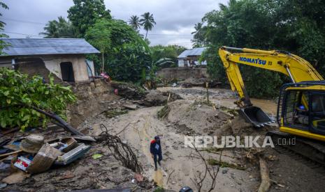 Operator alat berat membuat tanggl penahan arus air di dekat rumah yang ambruk akibat abrasi ditambah hujan deras (ilustrasi)