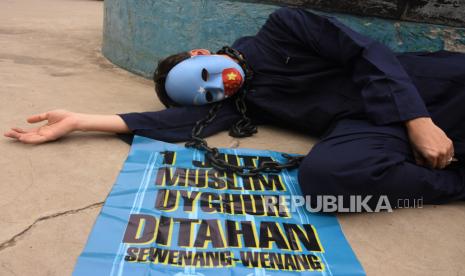 Pengunjuk rasa yang tergabung dalam Koalisi Indonesia Save Uyghur mengenakan topeng dan menggelar poster saat aksi solidaritas terhadap muslim Uighur di Taman Dukuh Atas, Jakarta, Selasa (4/1/2022). Mereka meminta pemerintah Indonesia untuk berbicara menentang genosida yang terjadi pada muslim Uighur di Xinjiang, memboikot Olimpiade Musim Dingin 2022 di Beijing serta menghentikan deportasi terhadap pencari suaka Uighur kembali ke China. Alasan Indonesia Tolak Debat Isu Uighur di Dewan HAM PBB