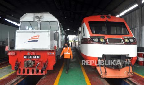 Petugas PT Kereta Api Indonesia melintas depan kereta api yang dibersihkan, di Depo Stasiun Simpang Haru, Padang, Sumatera Barat, Sabtu (25/4/2020). PT KAI  Divre II Sumbar membatalkan seluruh keberangkatan dan kedatangan perjalanan Kereta Api penumpang mulai 25 April 2020 hingga waktu yang belum ditentukan, dalam rangka mendukung kebijakan pemerintah tentang larangan mudik lebaran mencegah penyebaran COVID-19