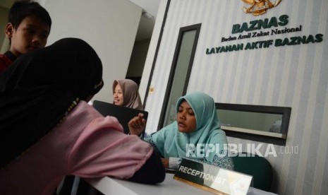 Petugas Badan Amil Zakat Nasional,melayani warga yang  datang ke kantor Baznas Tebet, Jakarta, Selasa (26/6).