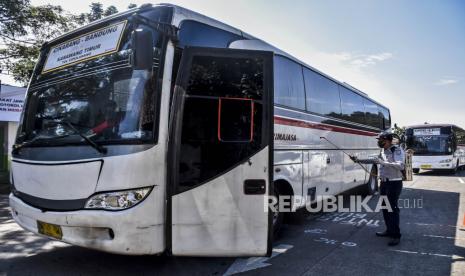 Petugas menyemprotkan cairan disinfektan ke badan bus yang baru tiba di Terminal Leuwipanjang, Kota Bandung, Ahad (14/6). Terminal Leuwipanjang mulai kembali beroperasi dengan tetap menerapkan protokol kesehatan bagi penumpang dan pengelola bus serta hanya membuka jalur trayek ke kawasan yang terdata zona kuning atau zona hijau selama masa pandemi Covid-19