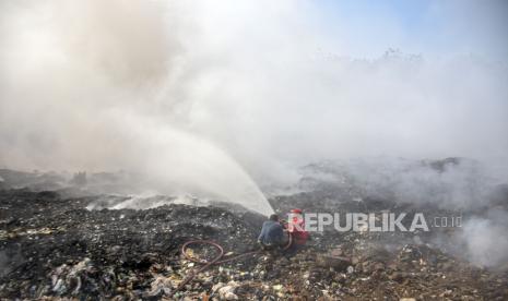 Petugas pemadam kebakaran (damkar) menyemprotkan air untuk memadamkan api di area tumpukan sampah TPA Sarimukti, Cipatat, Kabupaten Bandung Barat, Jawa Barat, Rabu (23/8/2023).