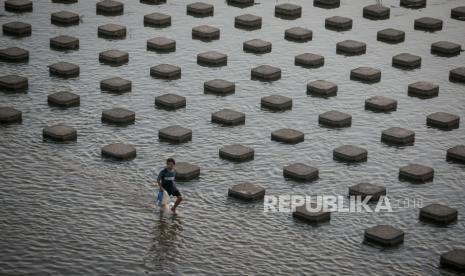 Warga mencari ikan saat melintas di samping beton pemecah arus air sungai di Bendungan Colo, Nguter Sukoharjo, Jawa Tengah, Sabtu (29/7/2023). Petani di wilayah irigasi Bendungan Colo meminta Balai Besar Wilayah Sungai Bengawan Solo (BBWSBS) untuk tidak menutup pintu air yang rutin tiap tahun dilakukan saat perawatan pada Oktober karena bertepatan dengan kemarau serta prediksi El Nino yang khawatirkan akan berdampak pada penurunan pasokan air irigasi sawah dan hasil panen petani. 