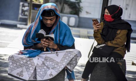 Warga membaca Al-quran sebelum melaksanakan ibadah Sholat Jumat di Masjid Raya Bandung, Jalan Dalem Kaum, Kota Bandung, Jumat (12/6). Masjid Raya Bandung kembali menggelar sholat jumat dengan menerapkan protokol kesehatan dan jaga jarak fisik (physical distancing) antarsaf serta membatasi jumlah jamaah menjadi 30 persen dari kapasitas masjid