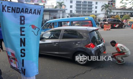 Petugas mengukur emisi gas buang sebuah kendaraan roda empat di jalan Trunojoyo, Malang, Jawa Timur, Rabu (26/7/2023). Dinas Lingkungan hidup setempat mengadakan uji emisi gratis bagi kendaraan roda empat atau lebih yang berbahan bakar bensin dan solar dalam rangka Evaluasi Kualitas Udara Perkotaan (Ekup) sebagai upaya mengurangi pencemaran udara dari bahan bakar minyak (BBM) kendaraan.  