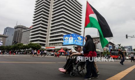 Penyandang disabilitas membawa bendera Palestina saat Aksi Damai Aliansi Rakyat Indonesia Bela Palestina di Jalan MH Thamrin, Jakarta, Ahad (5/11/2023). Aksi tersebut menuntut agar konflik antara Palestina dan Israel segera dihentikan dan dilakukan penyelidikan internasional atas kejahatan kemanusiaan yang dilakukan oleh Israel untuk diajukan ke Mahkamah Internasional. Mereka juga menentang keras penjajahan Israel atas Palestina dan mengecam keras politik apartheid, genosida dan holokaus serta terorisme yang terus dilakukan Israel. Hal ini adalah demi kemanusiaan perdamaian dan keadilan. Dalam pernyataannya, Aliansi Rakyat Indonesia Bela Palestina, demi kemanusiaan yang adil dan beradab, menyatakan sikap atas Tragedi Kemanusiaan terhadap Gaza, Palestina akibat agresi, kekejaman dan kezaliman Zionis Israel.