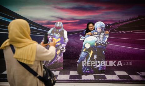 Warga berfoto di replika kendaraan motor di Bandara Udara Internasional Lombok Zainudin Abdul Madjid, Kabupaten Lombok Tengah, Nusa Tenggara Barat, Kamis (17/3/2022). Berbagai pernak pernik motoGP mulai memenuhi area Bandara Udara Internasional Lombok jelang gelaran MotoGP Pertamina Grand Prix of Indonesia yang akan berlangsung pada 18-20 Maret 2022 mendatang. Republika/Thoudy Badai