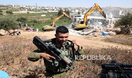 Tentara Israel berjaga-jaga saat buldoser militer menghancurkan sebuah rumah Palestina di kota Hebron, Tepi Barat, 03 Oktober 2022. Menurut pihak berwenang Israel, rumah itu dihancurkan karena dibangun tanpa izin. Tentara Israel Menghancurkan Masjid Dekat Hebron