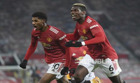 Marcus Rashford dari Manchester United, kiri, merayakan bersama Paul Pogba setelah mencetak gol pembuka dalam pertandingan sepak bola Liga Premier Inggris antara Manchester Utd dan Wolverhampton Wanderers di Stadion Old Trafford di Manchester, Inggris, Selasa, Desember. 29, 2020. 