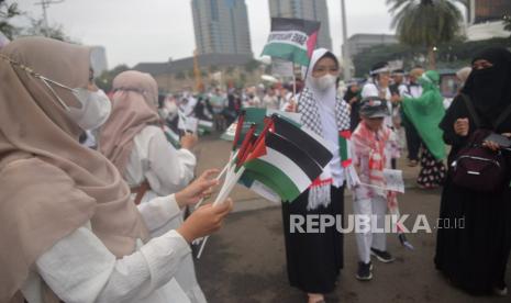 Sejumlah peserta aksi membagikan bendera palestina sebelum dimulainya Aksi DamaiAliansi Rakyat Indonesia Bela Palestina, di kawasan Monas,Ahad Jakarta (5/11/2023).