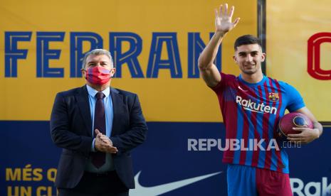 Striker Spanyol Ferran Torres (kanan) dan Presiden FC Barcelona, ??Joan Laporta, selama presentasi Torres sebagai pemain baru FC Barcelona di lapangan Stadion Camp Nou, di Barcelona, ??Spanyol, 03 Januari 2022. 