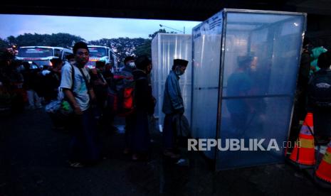 Sejumlah santri antre masuk ke dalam bilik disinfektan saat tiba di Terminal Tegal, Jawa Tengah, Selasa (31/3/2020). Dinas Kesehatan Kota Tegal memeriksa sebanyak 120 santri asal Tegal yang pulang dari Pondok Pesantren Lirboyo, Jawa Timur untuk mengetahui kondisi kesehatan mereka dalam upaya antisipasi penyebaran COVID-19