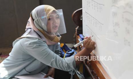  Guru Inggit Andini, yang memakai pelindung wajah sebagai antisipasi wabah virus corona, mengajar di kelas darurat di rumahnya di Tangerang, Senin (10/8). Anggota Komisi X DPR RI, Ledia Hanifa menilai risiko penularan Covid-19 akan selalu ada meskipun di zona kuning atau hijau. Terkait hal ini, perilaku siswa selama sekolah tatap muka dilaksanakan harus benar-benar dipantau.