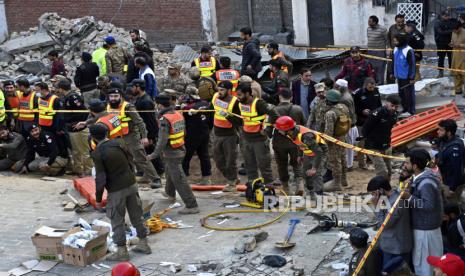  Petugas keamanan dan petugas penyelamat berkumpul di lokasi bom bunuh diri, di Peshawar, Pakistan, Senin, 30 Januari 2023. Seorang pembom bunuh diri menyerang di dalam sebuah masjid di kota Peshawar, Pakistan barat laut, menewaskan banyak orang dan melukai puluhan jamaah , kata para pejabat.