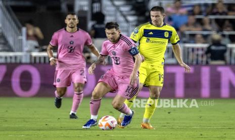 Penyerang Inter Miami Lionel Messi (tengah) beraksi melawan Alex Muyl (kanan) dari Nashville SC selama pertandingan sepak bola Piala Champions CONCACAF antara Inter Miami CF dan Nashville SC di Fort Lauderdale, Florida, AS, Kamis (14/3/2024).