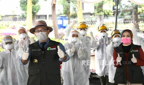 Gubernur Jawa Barat Ridwan Kamil didampingi Ketua Jabar Bergerak Atalia Praratya berfoto bersama para petugas medias saat meninjau pelaksanaan Rapid test Covid-19 secara drive-thru, di Gedung Sate, Kota Bandung, Sabtu (4/4). Diharapkan dari hasil tes masif oleh Pemdaprov Jawa Barat secara merata di seluruh kabupaten dan kota bisa diketahui maksimal dua pekan ke depan untuk mengetahui pemetaan persebaran Covid-19