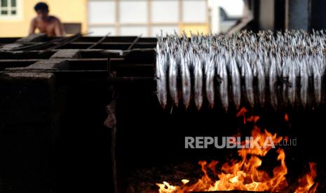 Seorang pekerja menunggu ikan Dehu yang dimasak dengan cara pengasapan di Hulawa, Kabupaten Gorontalo, Gorontalo, Selasa (7/4/). Satuan Kerja Khusus Pelaksana Kegiatan Usaha Hulu Minyak dan Gas Bumi (SKK Migas) tengah menyiapkan petunjuk teknis (Juknis) implementasi kebijakan penyesuaian harga gas bumi untuk sektor industri. Juknis tersebut merupakan turunan dari peraturan perundangan yang diterbitkan Menteri ESDM pada April 2020.