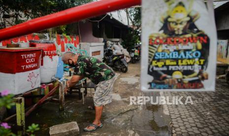 Warga mencuci tangan sebelum memasuki area zona merah RW 03 Kelurahan Kebon Manggis, Jakarta, Rabu (15/7). Jumlah rukun warga (RW) yang termasuk Wilayah Pengendalian Khusus (WPK) zona merah COVID-19 bertambah sebanyak tiga RW menjadi 30 RW yang tersebar di beberapa daerah di DKI Jakarta.