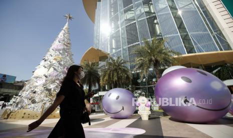 Seorang wanita berjalan melewati dekorasi musim perayaan untuk mempromosikan penjualan di sebuah pusat perbelanjaan di Bangkok, Thailand, 14 Desember 2022. Thailand berencana untuk memungut biaya 300 baht atau sekitar Rp 138.000 dari wisatawan asing yang tiba di negara tersebut. 