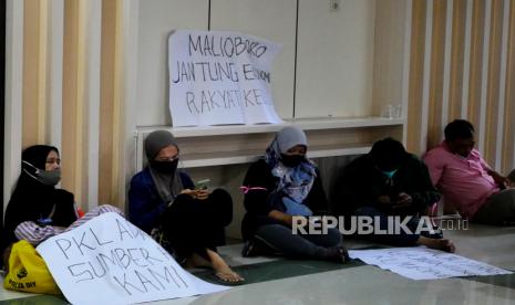 Pedagang kaki lima Malioboro membawa poster saat audensi dengan anggota DPRD Kota Yogyakarta di Gedung DPRD Kota Yogyakarta, Senin (17/1/2022). Pedagang kaki lima Malioboro mengadu ke DPRD Kota Yogyakarta terkait rencana relokasi PKL ke tempat baru yakni di bekas Bioskop Indra dan lahan eks Dinas Pariwisata Yogyakarta pada awal Februari 2022. Pedagang kaki lima meminta penundaan relokasi satu hingga tiga tahun mendatang.