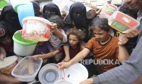 Warga Palestina antre untuk mendapatkan makanan selama pengeboman Israel yang sedang berlangsung di Jalur Gaza di Rafah pada Senin, 13 November 2023.